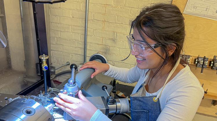 Arusha N learning how to use the metal lathe while making custom rings for friends.